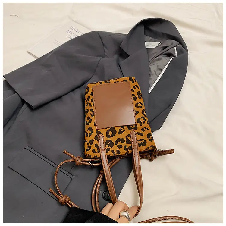 Retro leopard print suede mini bucket crossbody bag with brown leather flap and matching drawstring handles.