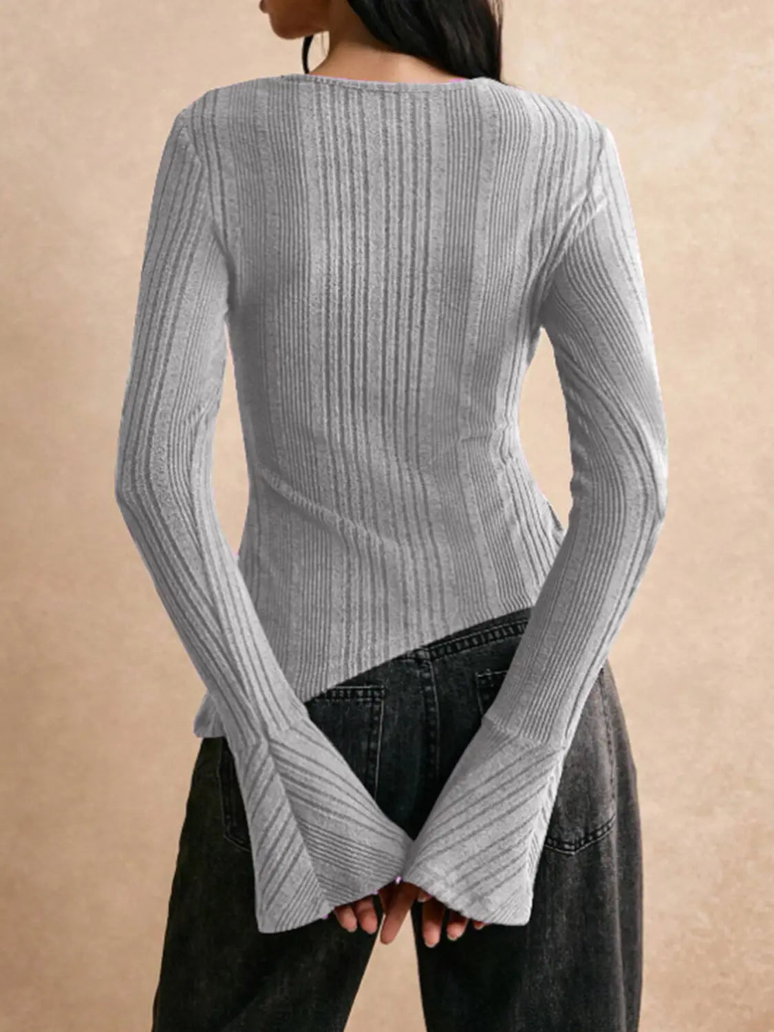 A light gray ribbed knit long sleeve cutout top with a flared bell-shaped hem.
