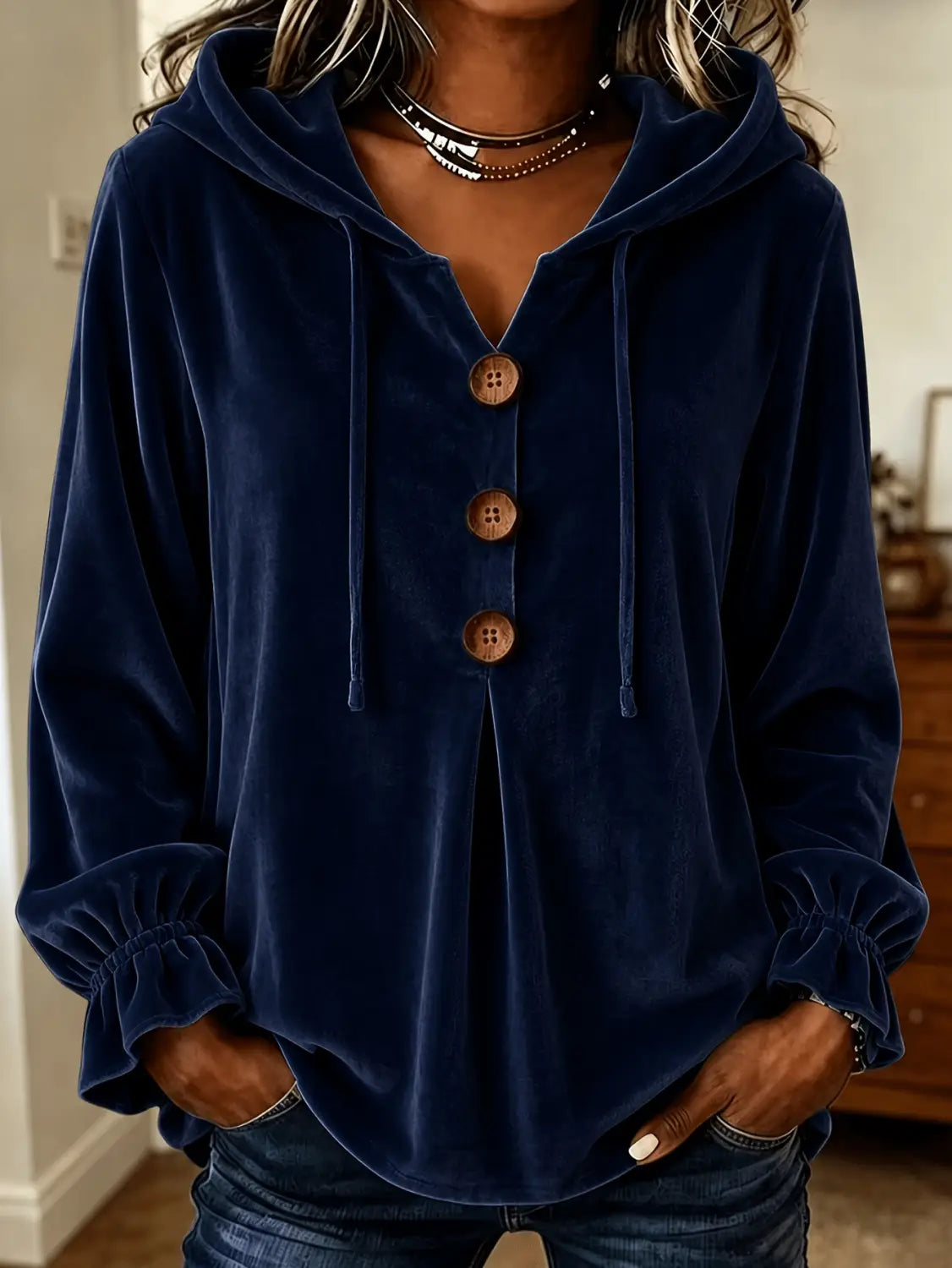 Sudadera de terciopelo azul marino con botones de madera y puños fruncidos, exhibida de frente.