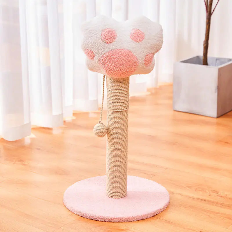 Ein Kratzbaum für Katzen aus Sisal mit vertikalem, langlebigem Spielzeugpfosten verfügt über eine weiche Plüschpfote in Hellrosa mit dunkleren rosa runden Akzenten auf einem beigen, mit Sisal umwickelten Kratzpfosten sowie über eine dazu passende rosafarbene runde Standfläche.