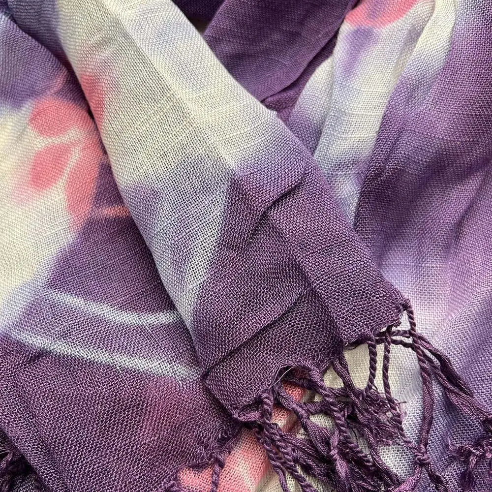 Un foulard en viscose bohème floral violet souple, avec des teintes tie-dye de violet et de rose, une trame texturée et des bords frangés.