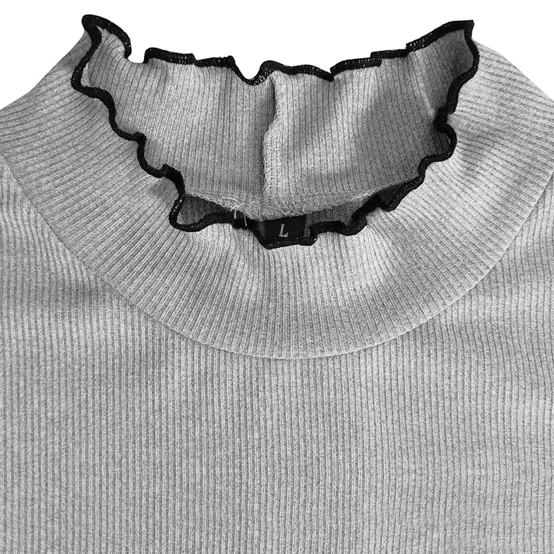 Gray ribbed knit slim fit mock neck top with a black ruffled collar trim for women.