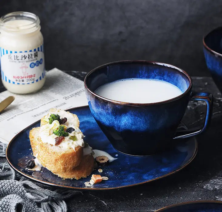 Deep blue ceramic coffee mug and saucer set with a glossy gradient finish.