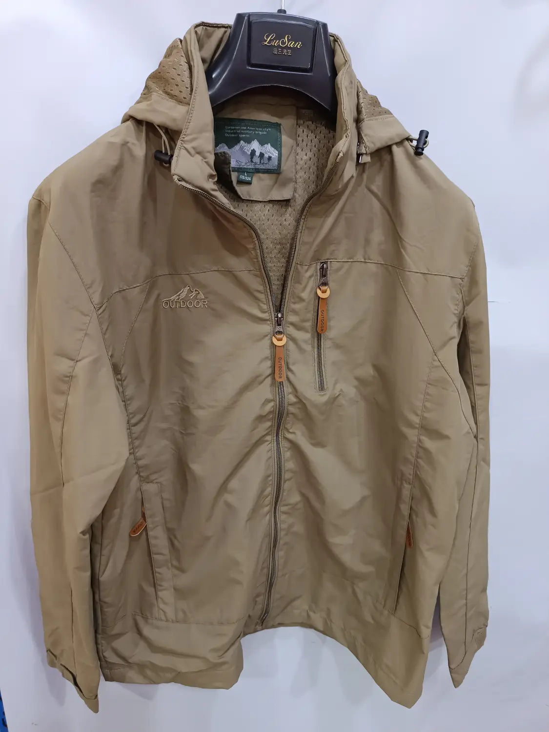 Chaqueta de senderismo con capucha impermeable ligera en color camel, con cremallera frontal, con tiradores de cremallera de cuero.