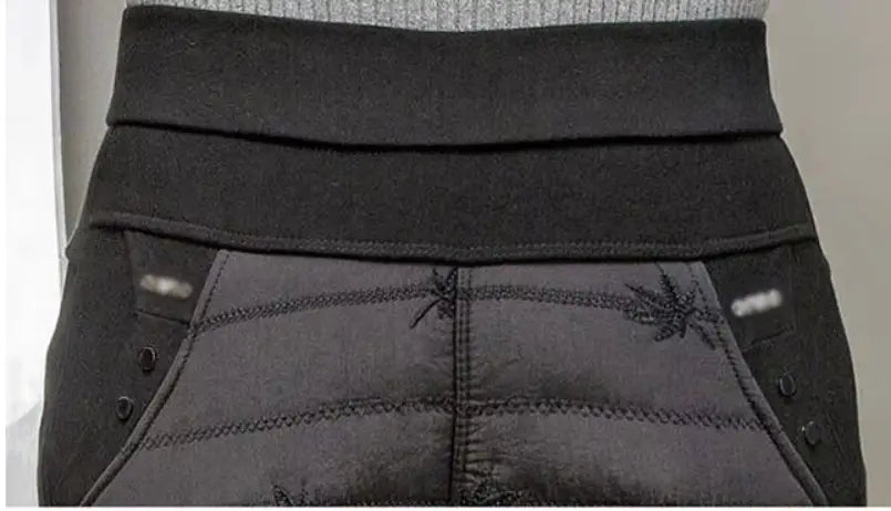 Jeans de maternidad negros con cintura elástica y detalles decorativos de costuras, forrados con felpa, pantalones tipo lápiz de invierno de cintura alta, mostrados desde el lado trasero.