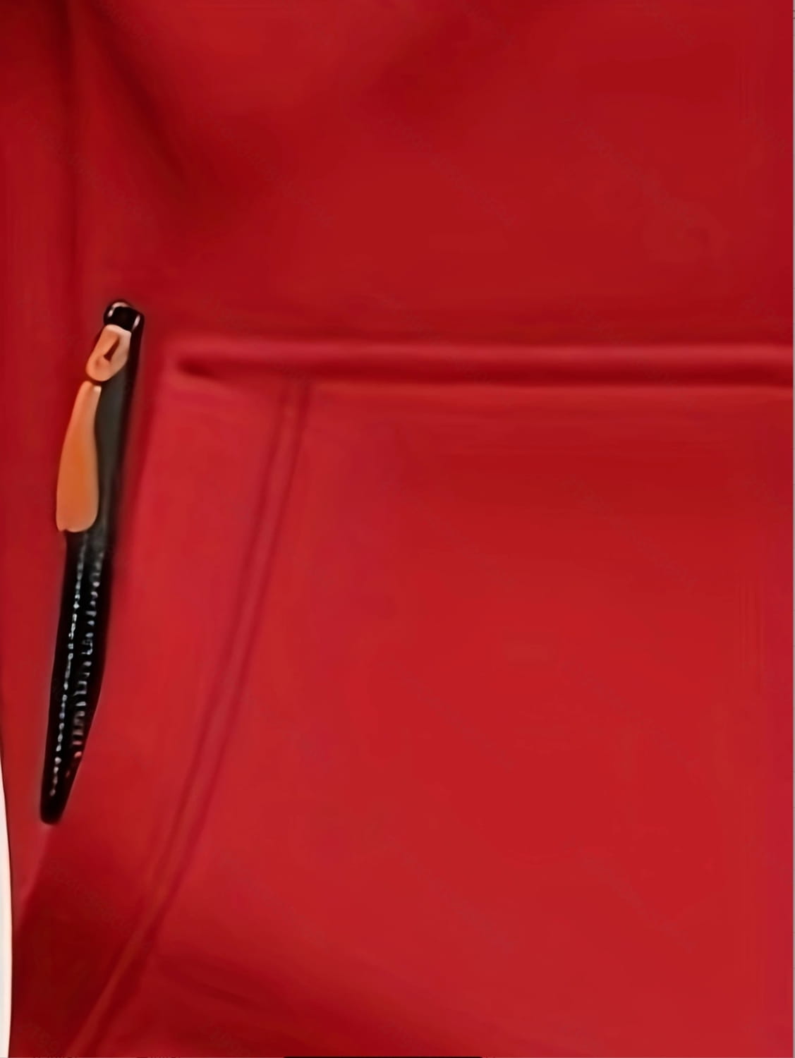 Black zipper with tan pull tab on men’s sport casual fleece lined zipper hoodie jacket over red fabric.