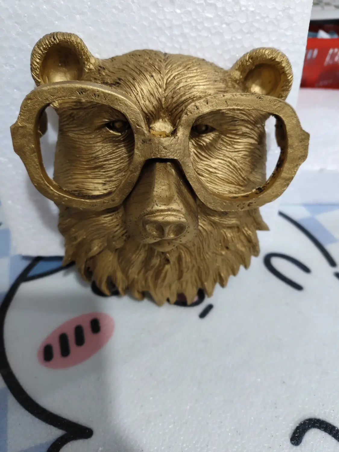 golden bear head sculpture wall decor with oversized round glasses featuring textured fur and a polished brass resin finish.
