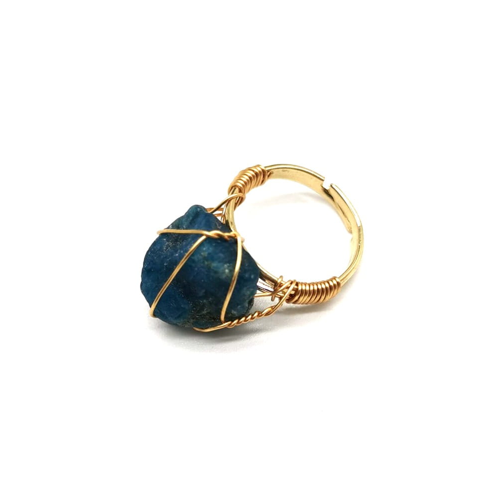 A handcrafted gold wire wrapped adjustable ring featuring a raw deep blue gemstone.