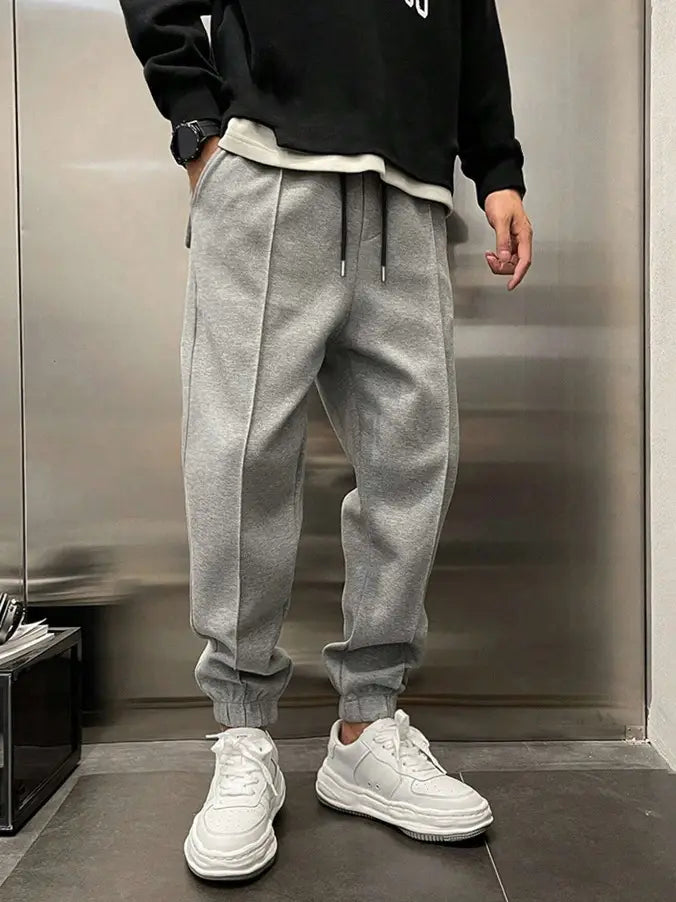 Men’s fleece drawstring sweatpants in gray with an elastic cuff and a drawstring waist for comfort.