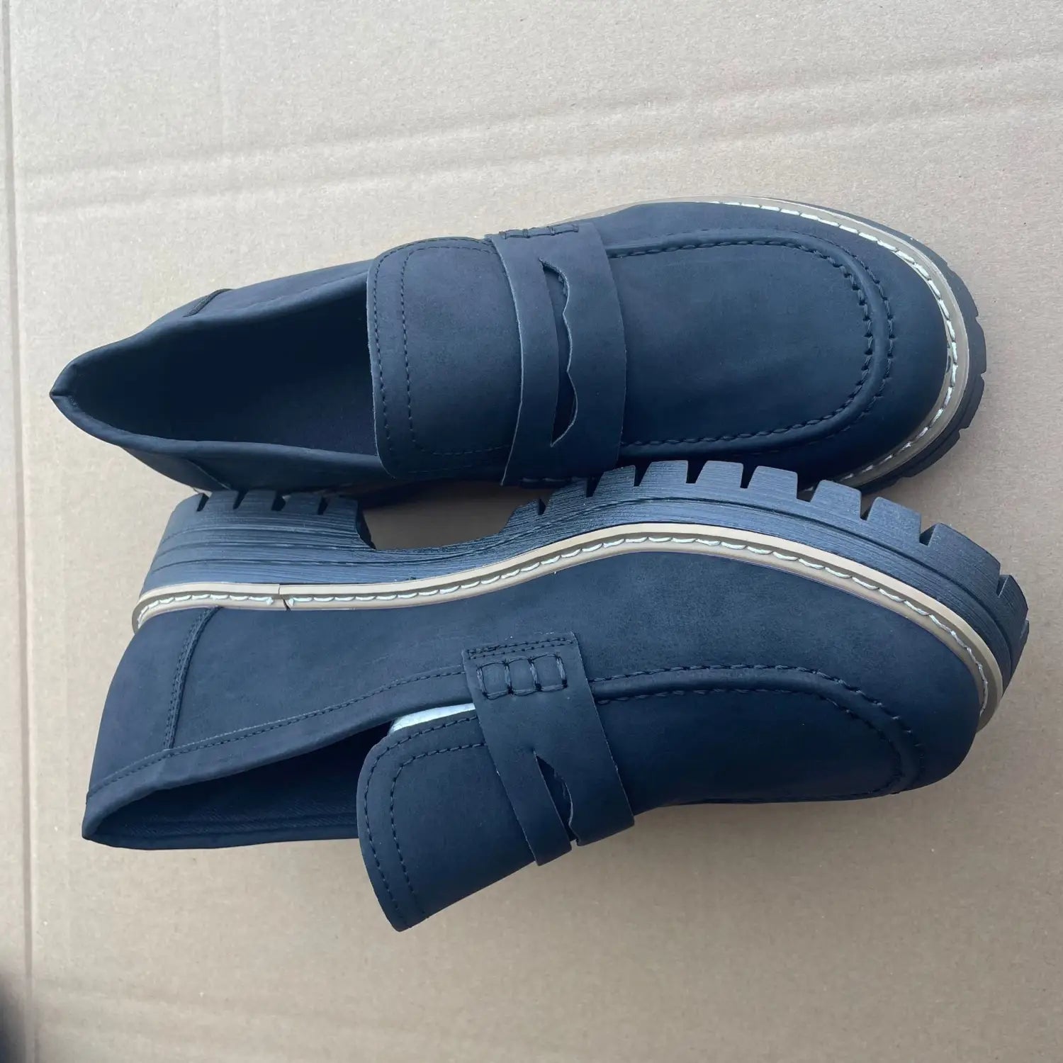 Dunkelblaue Plateau-Loafer aus Wildleder für Damen mit massiven Gummisohlen und weißen Ziernähte, entworfen für den Freizeitgebrauch.