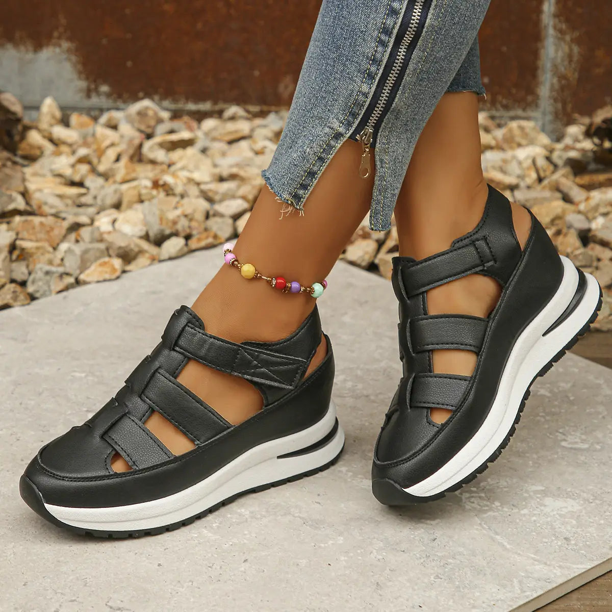 Black breathable hollow wedge platform sandals with multiple velcro strap closures and a white rubber sole.