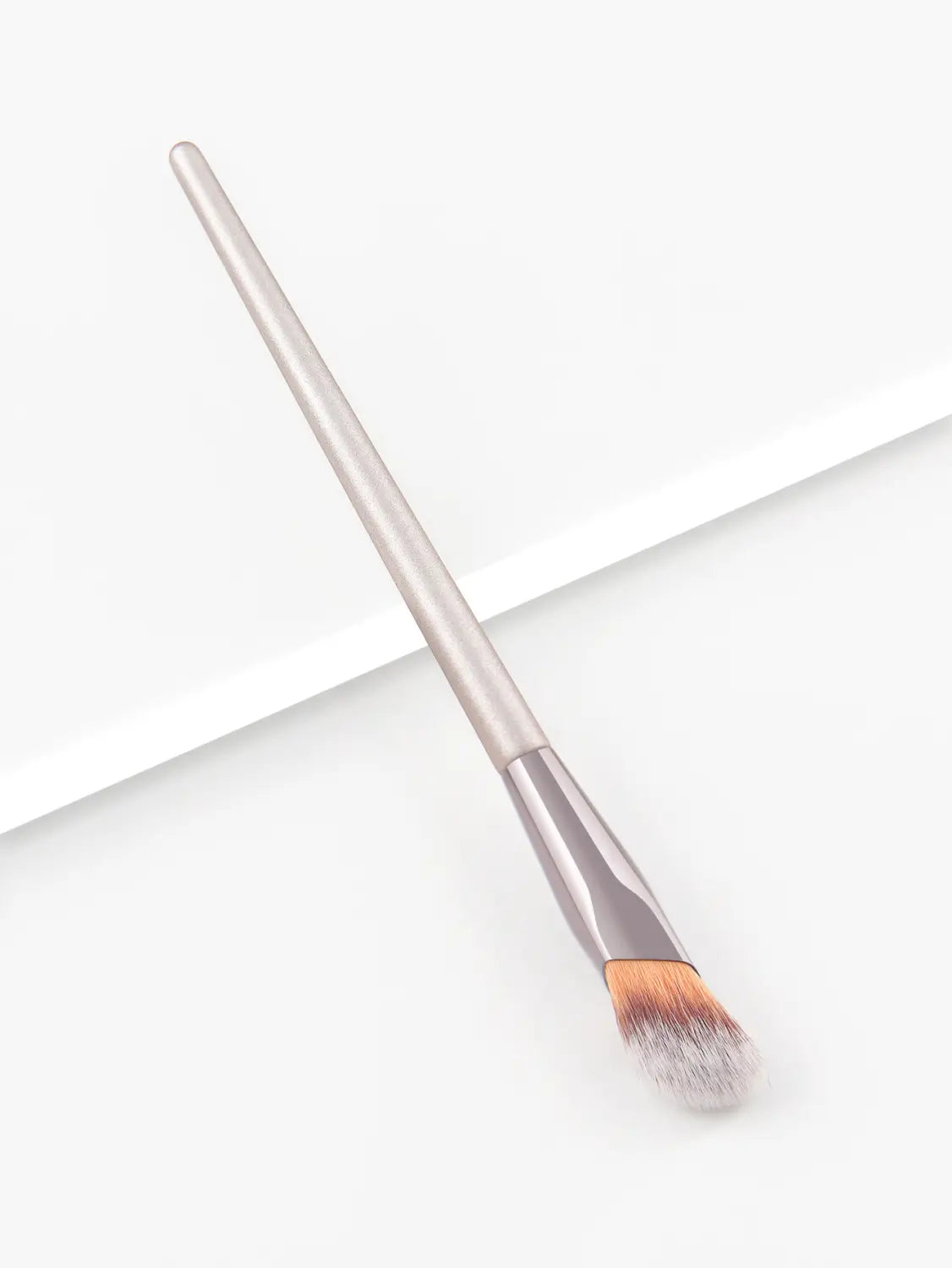 Silver-handled finger belly makeup brush with a gradient of orange and white bristles designed for professional contouring.