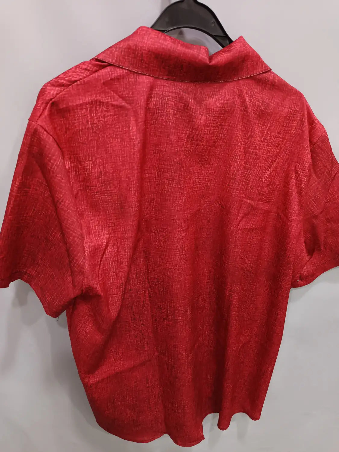 Ein kräftiges rotes Herrenhemd aus Baumwoll-Leinen mit Streifenmuster, mit strukturiert gewebtem Stoff und klassischem Kragen.