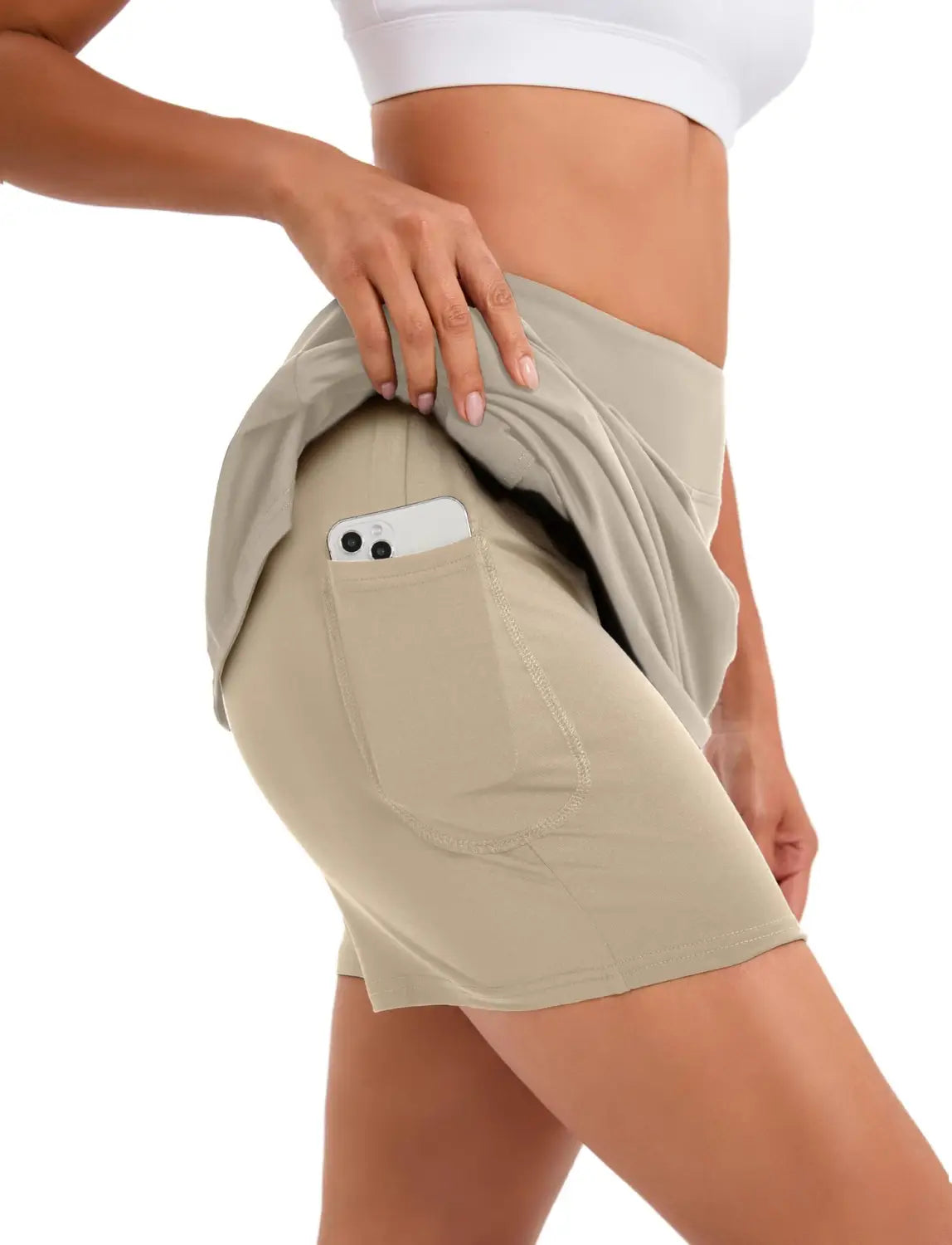 beige paisley high-waisted athletic tennis skirt featuring a side pocket holding a smartphone for convenient storage during sports activities
