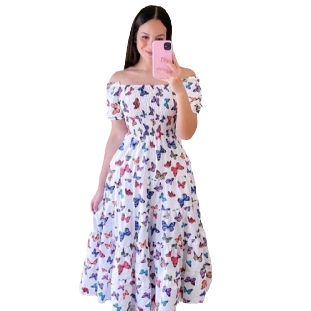 A white off-the-shoulder maxi dress with a vibrant multicolored butterfly print and smocked tiered design with a square neckline.