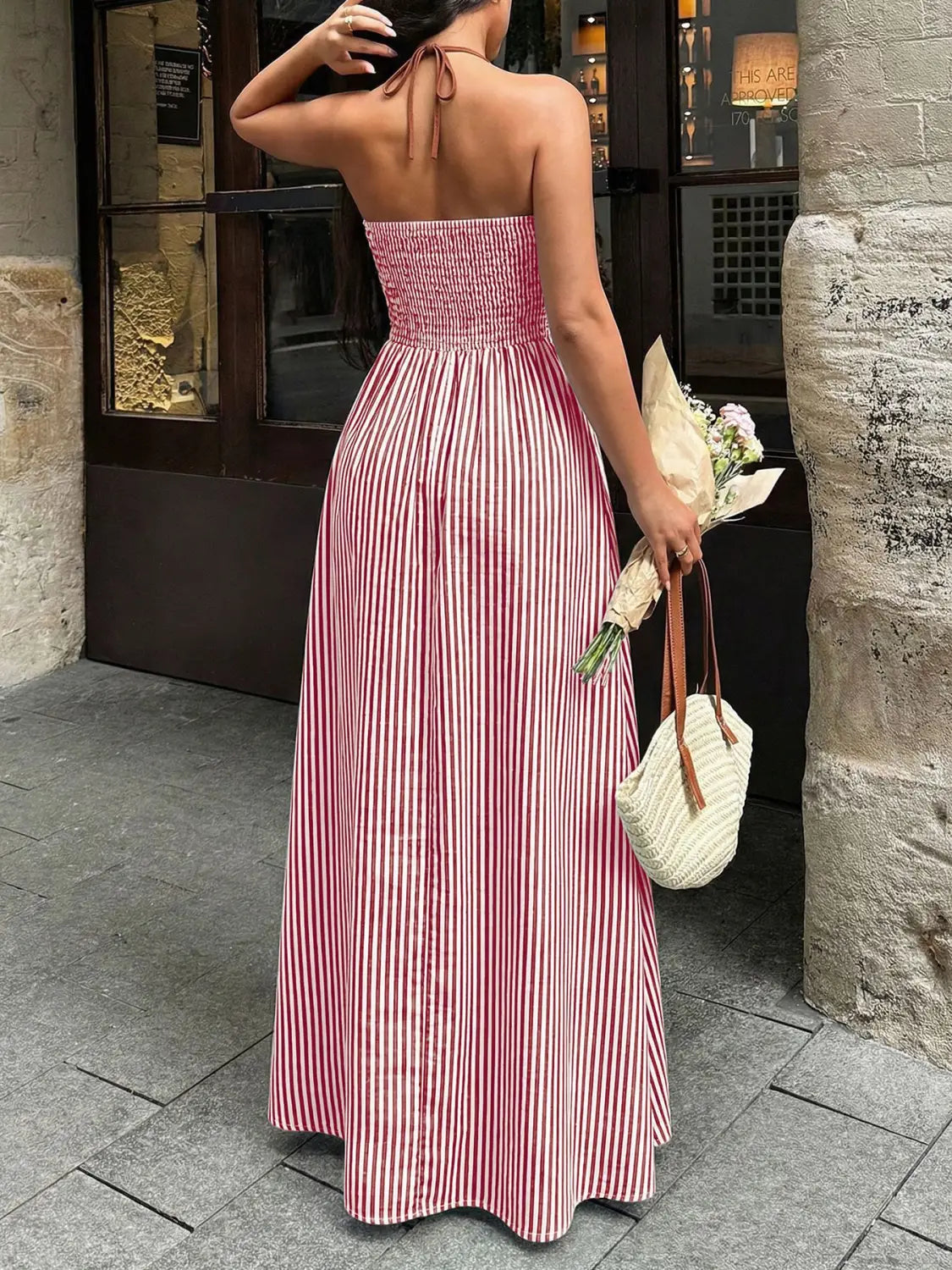 une robe maxi d’été ample et fluide à rayures verticales rose et blanche, avec un corsage froncé ajusté et un détail dos noué à encolure en V