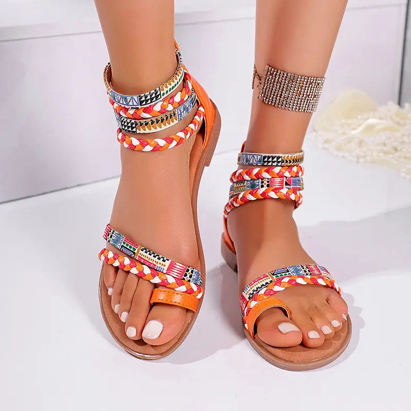 orange and multicolored bohemian ethnic braided ankle strap flat sandals with intricate patterned fabric straps