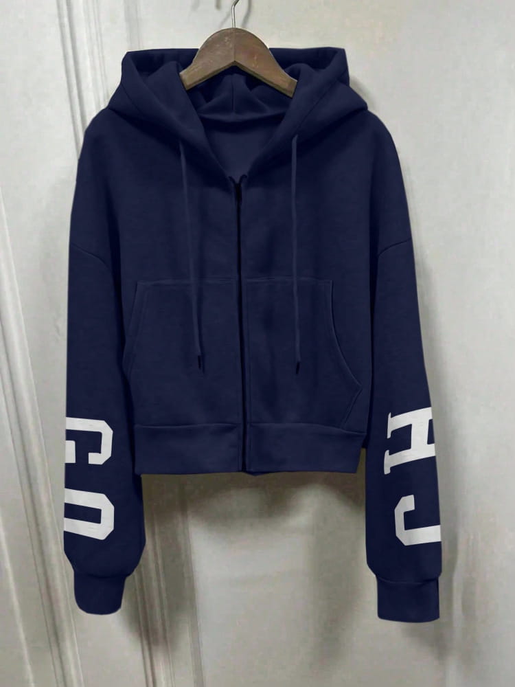Hoodie zippé court bleu marine, avec des lettres blanches sur les manches, présentant un design de sweat-shirt à capuche zippé imprimé graphique.