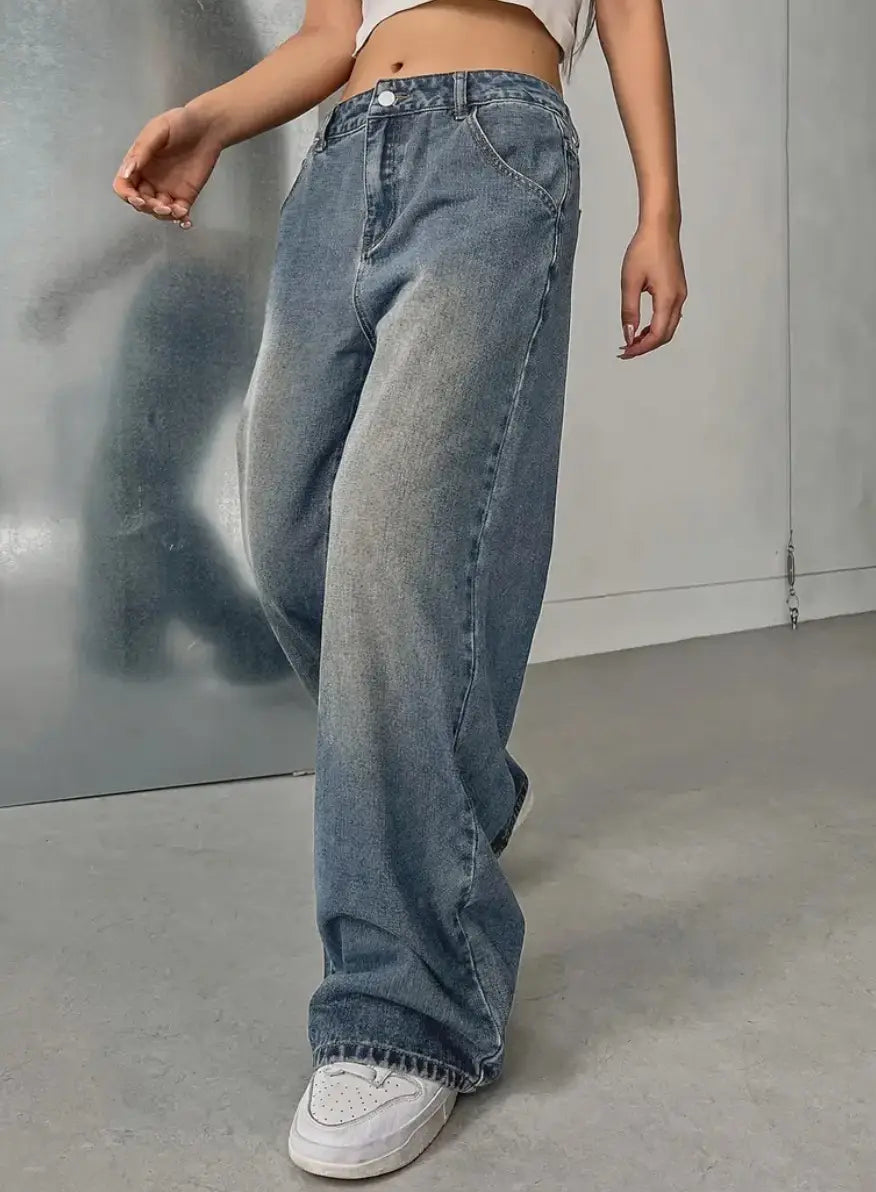 Jeans en denim vintage délavé à jambes larges en bleu délavé, avec un léger effet vieilli le long des coutures.