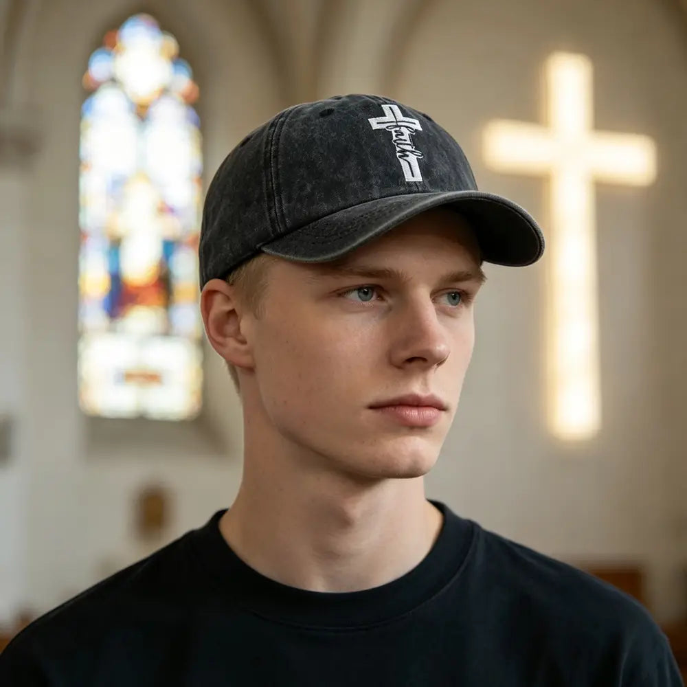 Black denim baseball cap with a white embroidered cross design featuring a distressed vintage style.