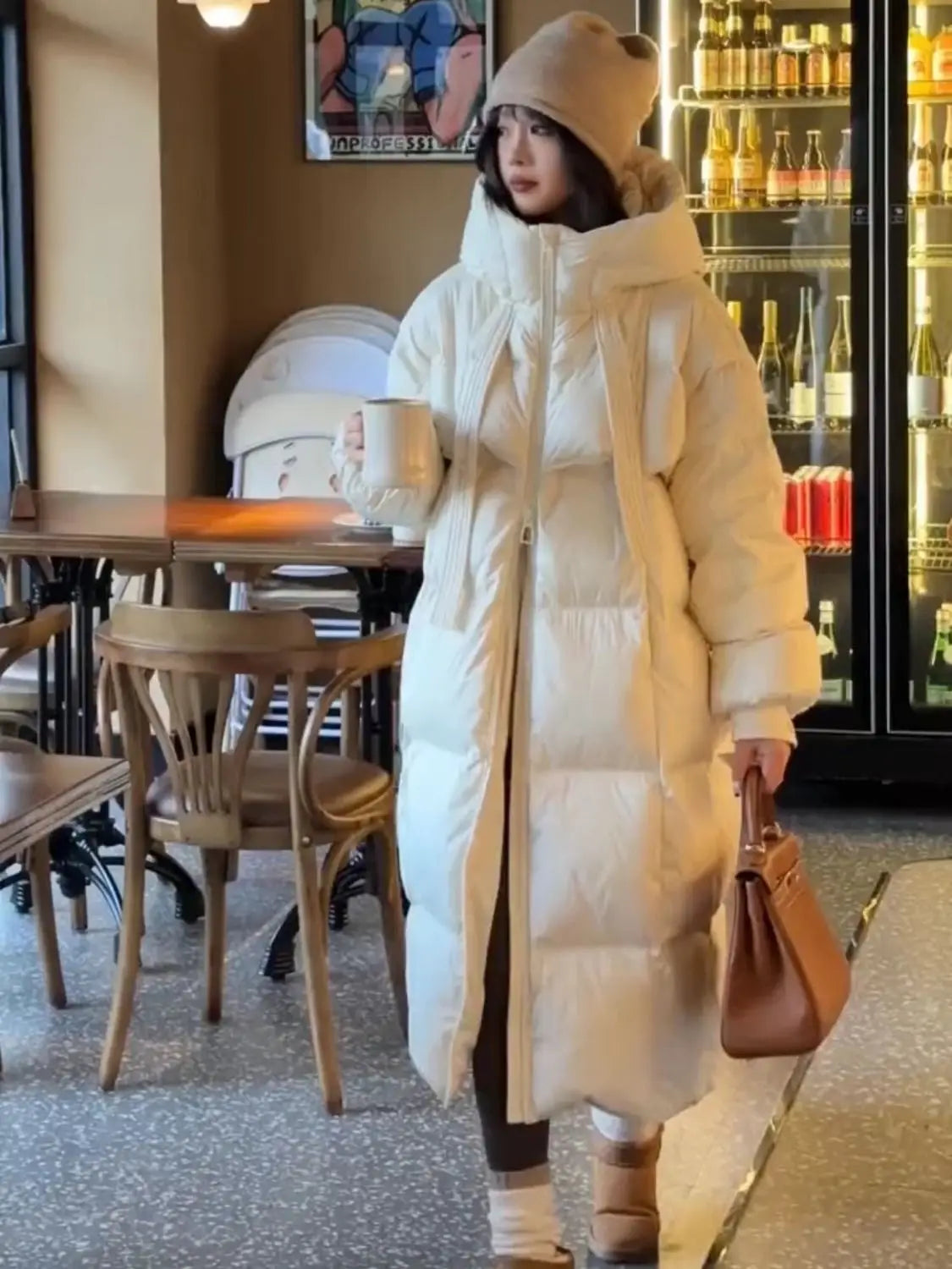 cream-colored women long padded down jacket quilted coat with hood and long sleeves made of insulating down material