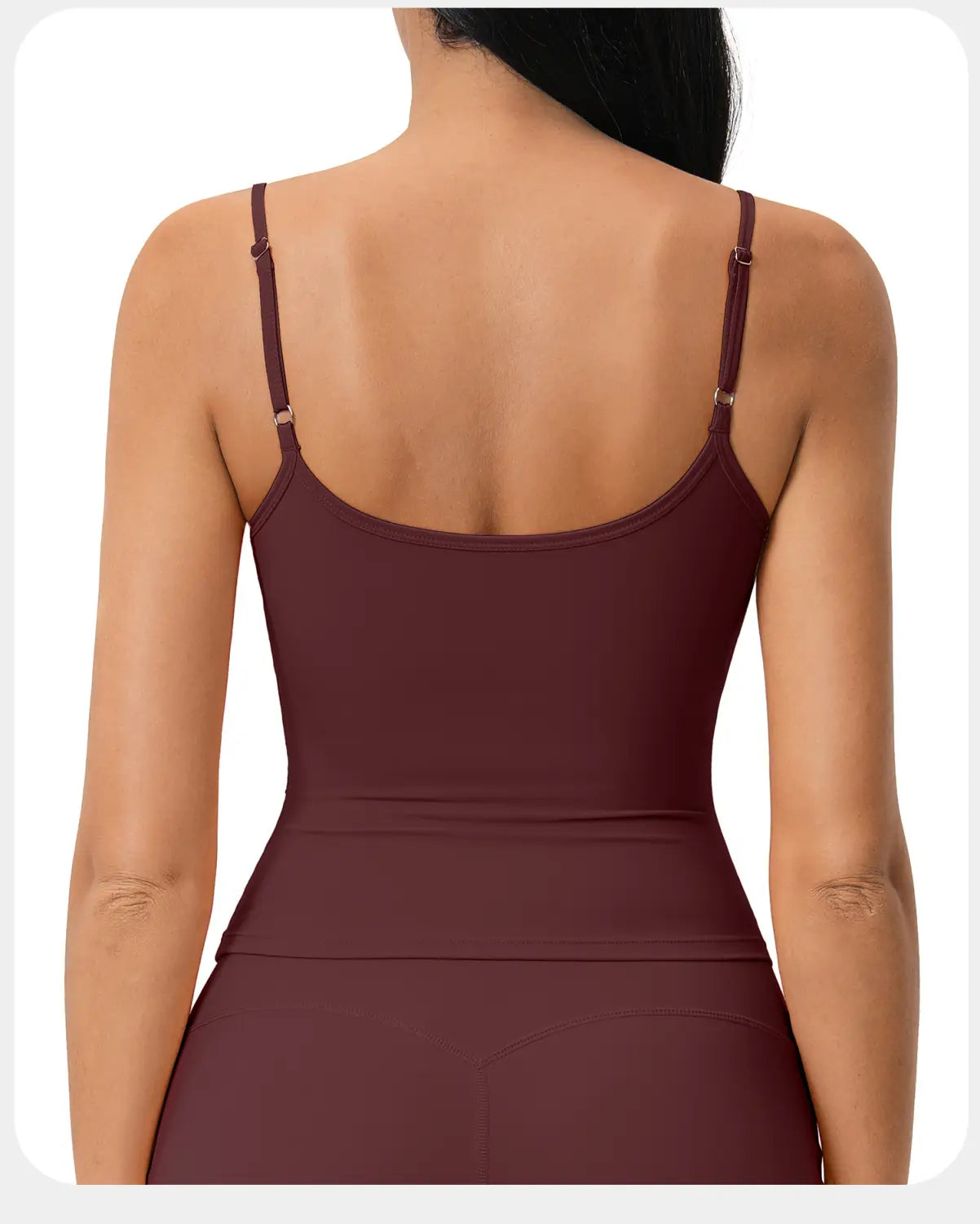 Una camisola deportiva sin mangas acolchada burdeos con tirantes finos ajustables, confeccionada con tela lisa, elástica y de secado rápido, diseñada para ropa deportiva de entrenamiento.
