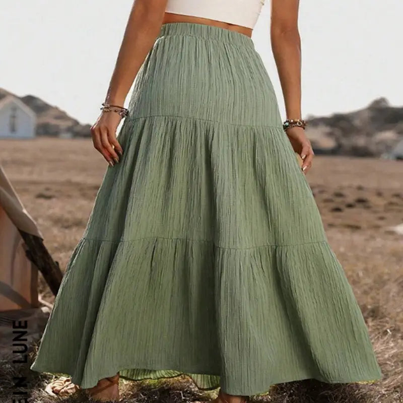 A flowing sage green lightweight tiered maxi skirt with a gathered waist and subtle vertical pleats designed for casual wear.