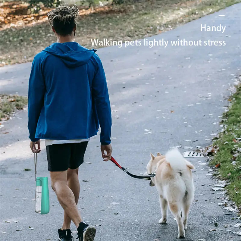 シルバーカラーのハンドルとループ付きのティール半透明携帯用犬用ウォーターボトル。550mlの折りたたみ式ペットトラベルカップとして設計されています。