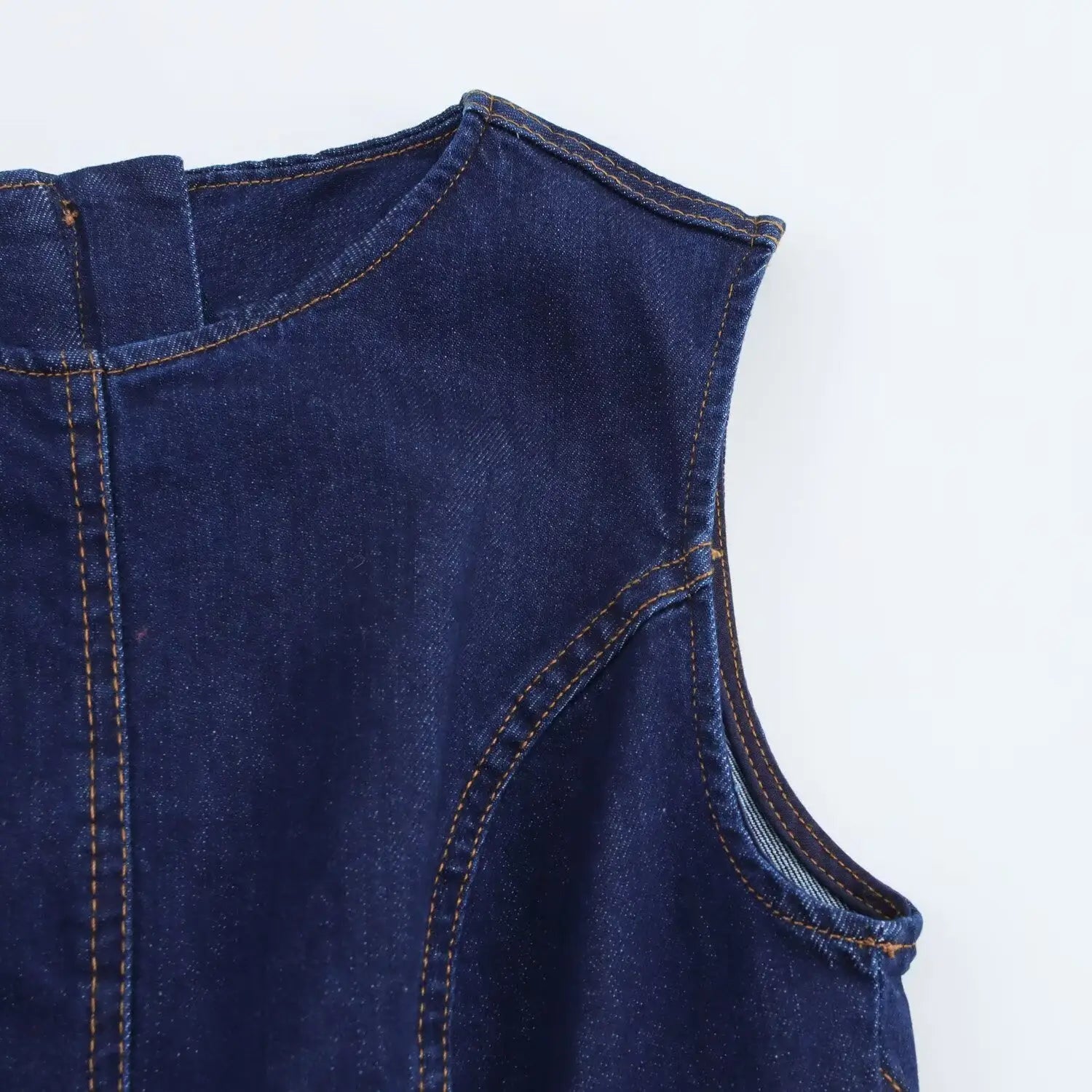 Navy crew neck sleeveless denim a-line dress featuring dark blue denim fabric with visible stitching and a slightly worn texture.
