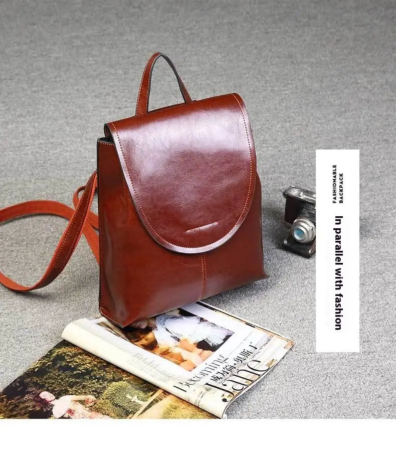 Una mochila bandolera de cuero marrón intensa con un diseño minimalista y elegante, y correas a juego, ideal para el uso en moda retro.
