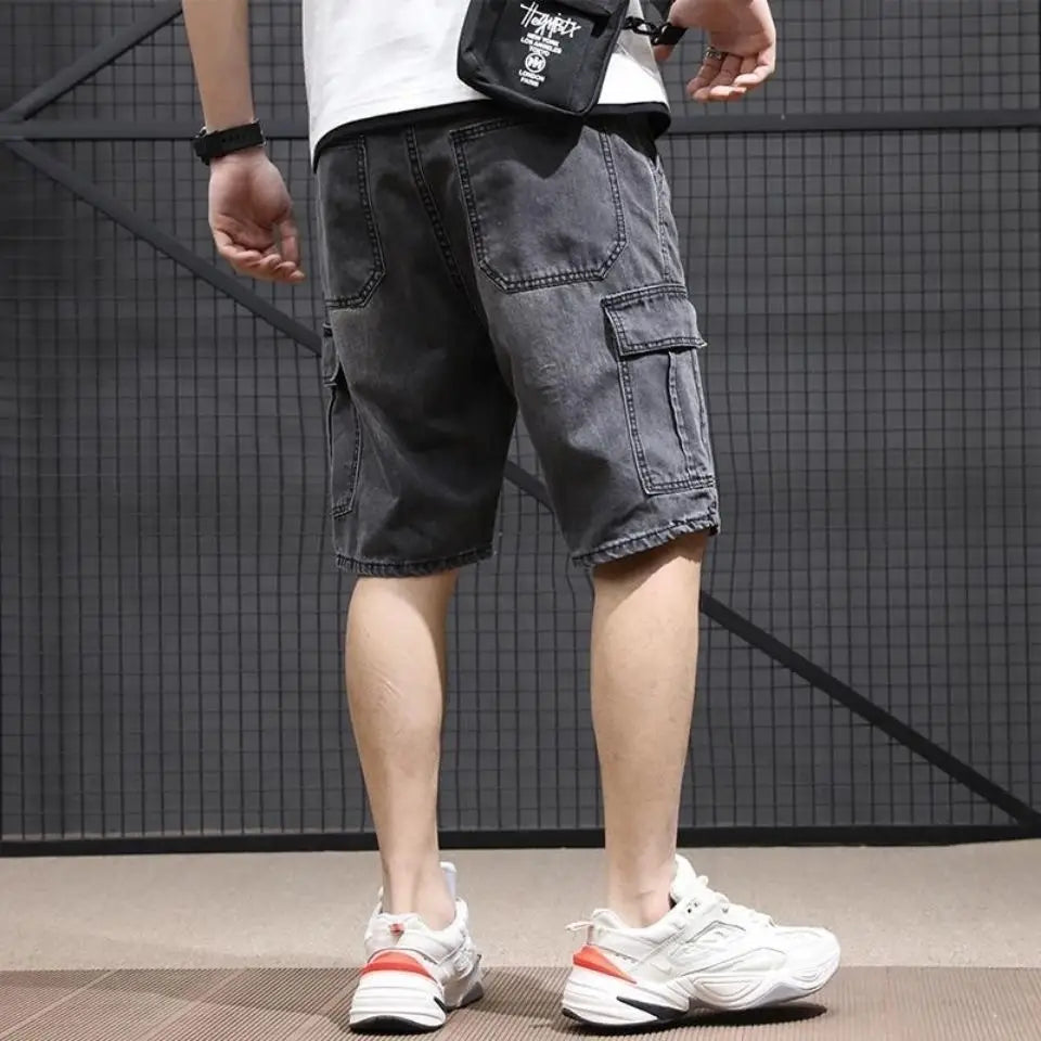 Dark gray denim cargo shorts for youth workwear featuring multiple pockets and a slightly worn, faded finish.