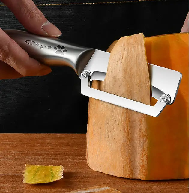 Trancheur de fromage en métal argenté avec logo d’empreinte de patte sur la poignée, montré comme le côté arrière d’un coupe-légumes en acier inoxydable avec poignée en bois.