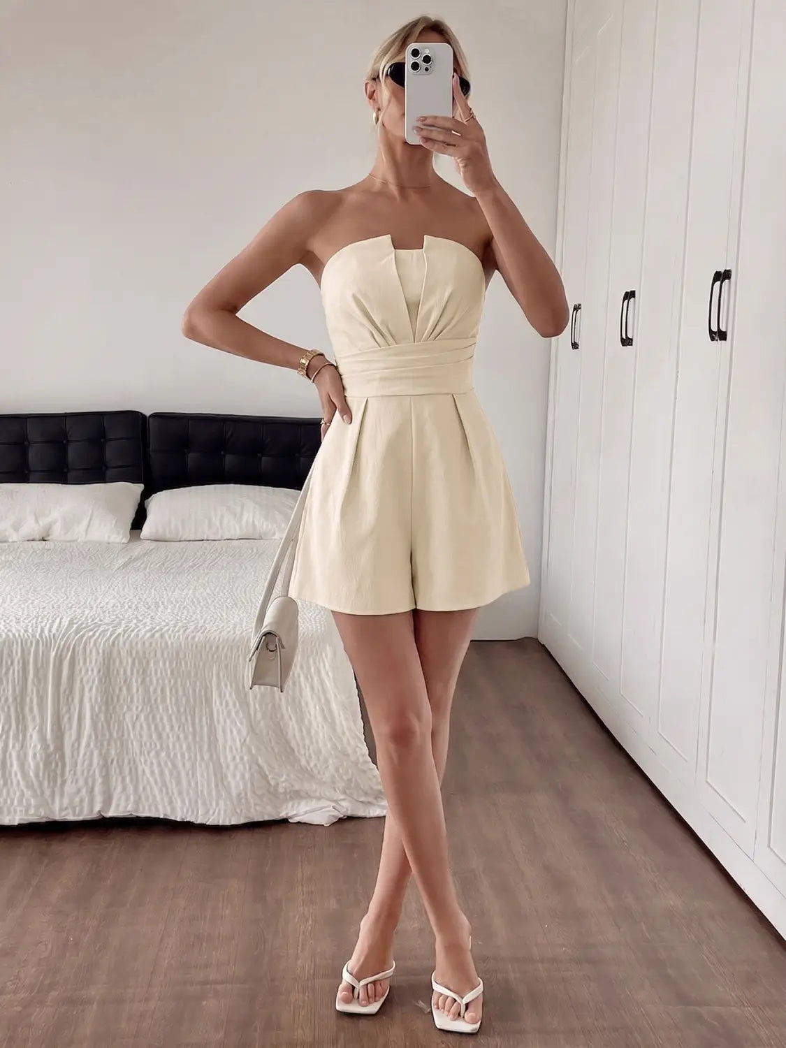 Cream strapless pleated jumpsuit in cream color with a gathered waist and flared shorts designed for a stylish and comfortable fit.