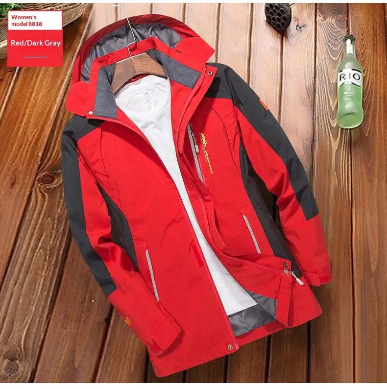 Veste coupe-vent de randonnée imperméable pour hommes en rouge et gris foncé, avec panneaux noirs sur les manches et les épaules, munie d’une capuche et adaptée aux activités en extérieur.