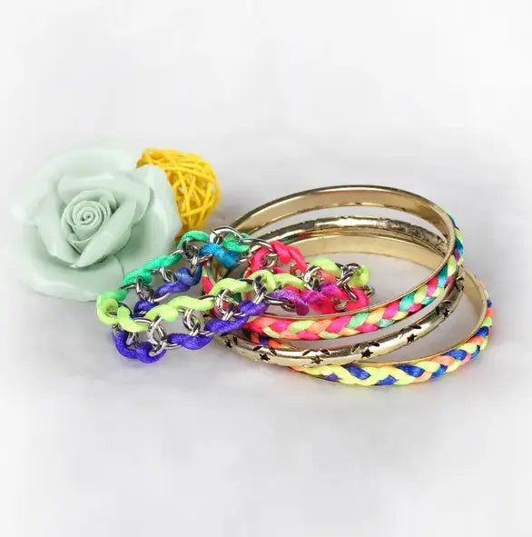 A set of neon braided gold bangle bracelets with colorful hues and metallic chain accents featuring star details.