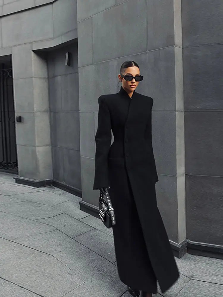 Charcoal gray wool coat for women featuring a structured design with dramatic shoulder pads and a high collar, ideal for long outerwear.