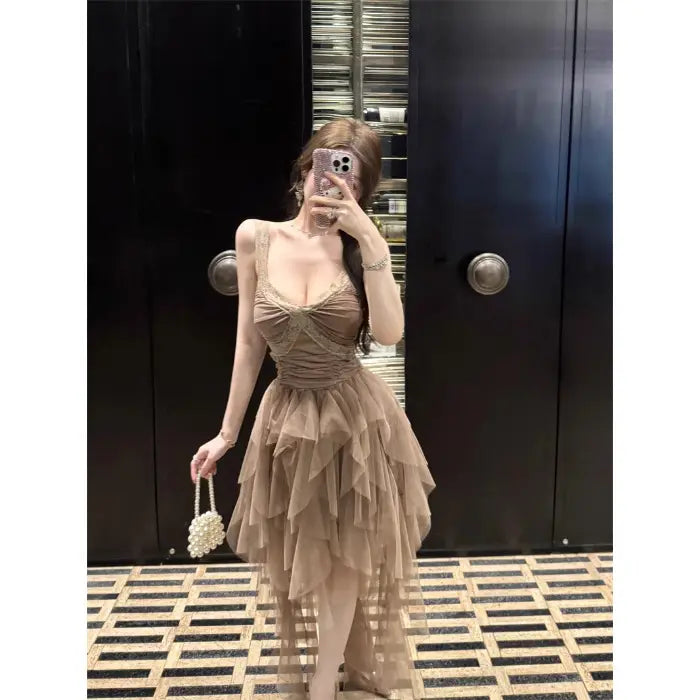 A beige tiered tulle and lace mesh evening gown with a fitted bodice and delicate lace detailing.
