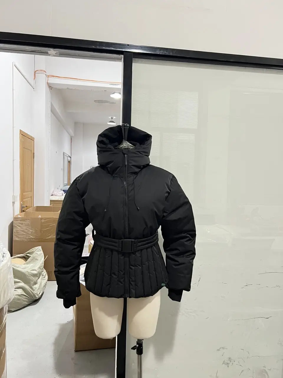 Black quilted puffer jacket with hood and belted waist designed for women style and warmth.