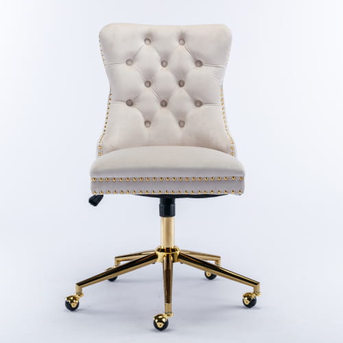 Silla de oficina de terciopelo color beige con botones tipo capitoné, base metálica de tono dorado y remate con tachuelas, diseñada para uso en espacios de trabajo profesionales.