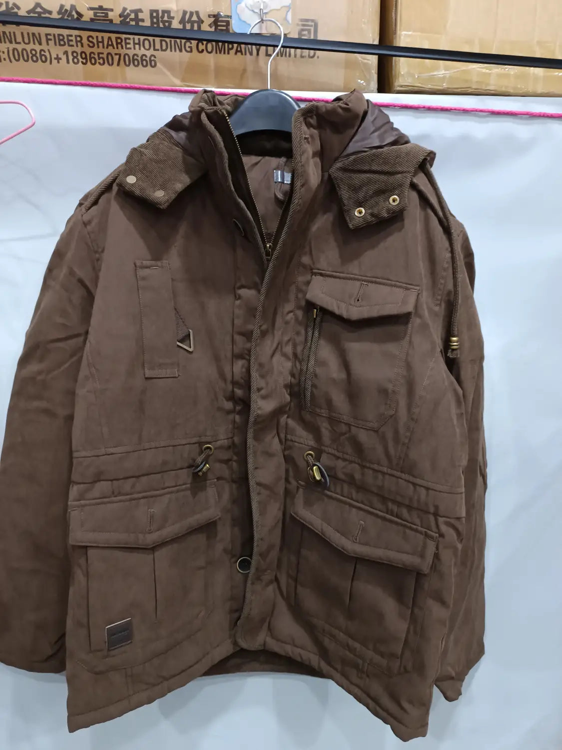 Chaqueta de invierno con capucha marrón para tallas grandes, con forro de lana polar, múltiples bolsillos y cierre con cremallera, diseñada para el clima frío.