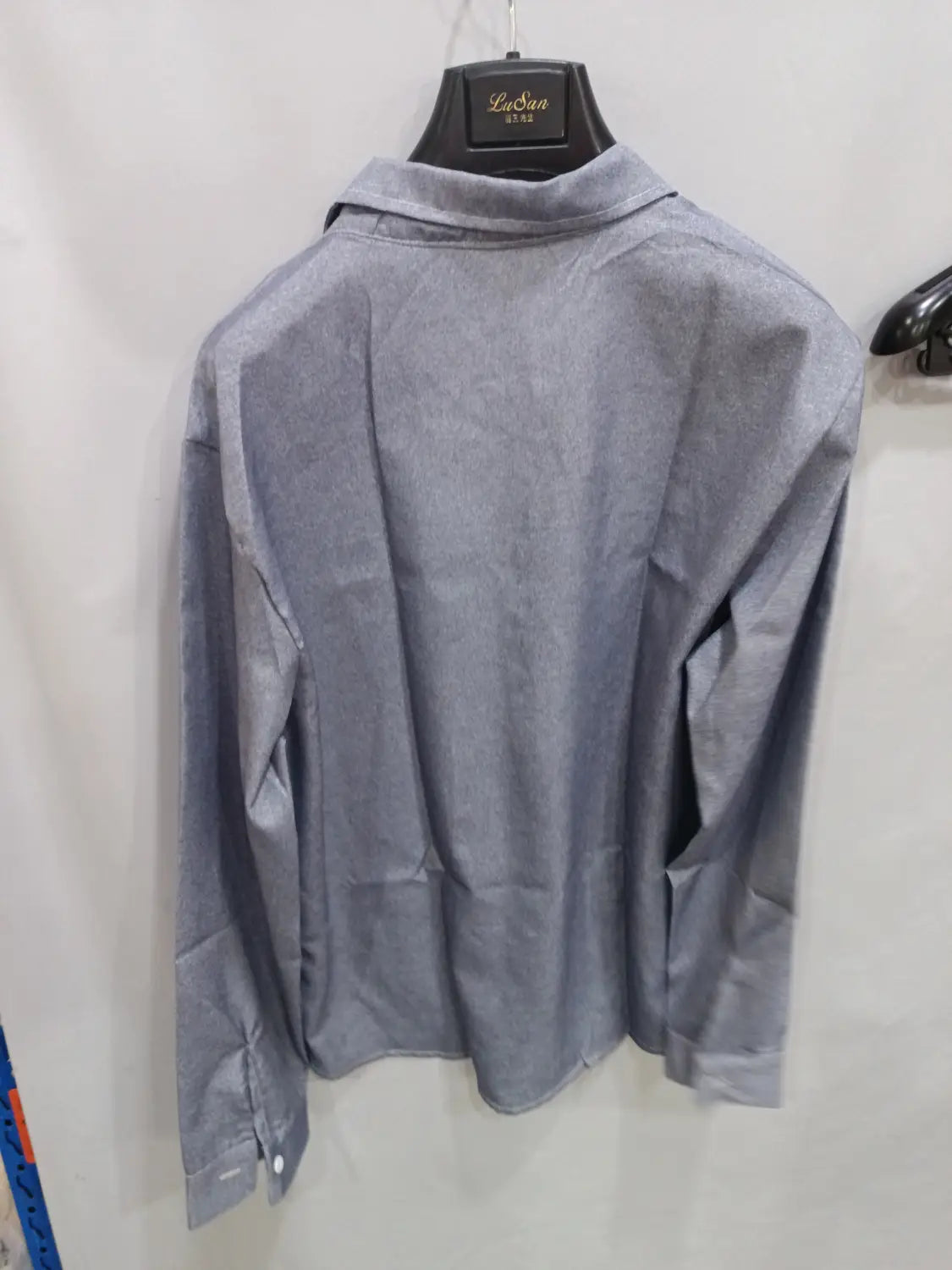 Herren-Texturiertes Hemd mit langen Ärmeln, grau, das an einem schwarzen Bügel hängt, geeignet für Business-Casual.