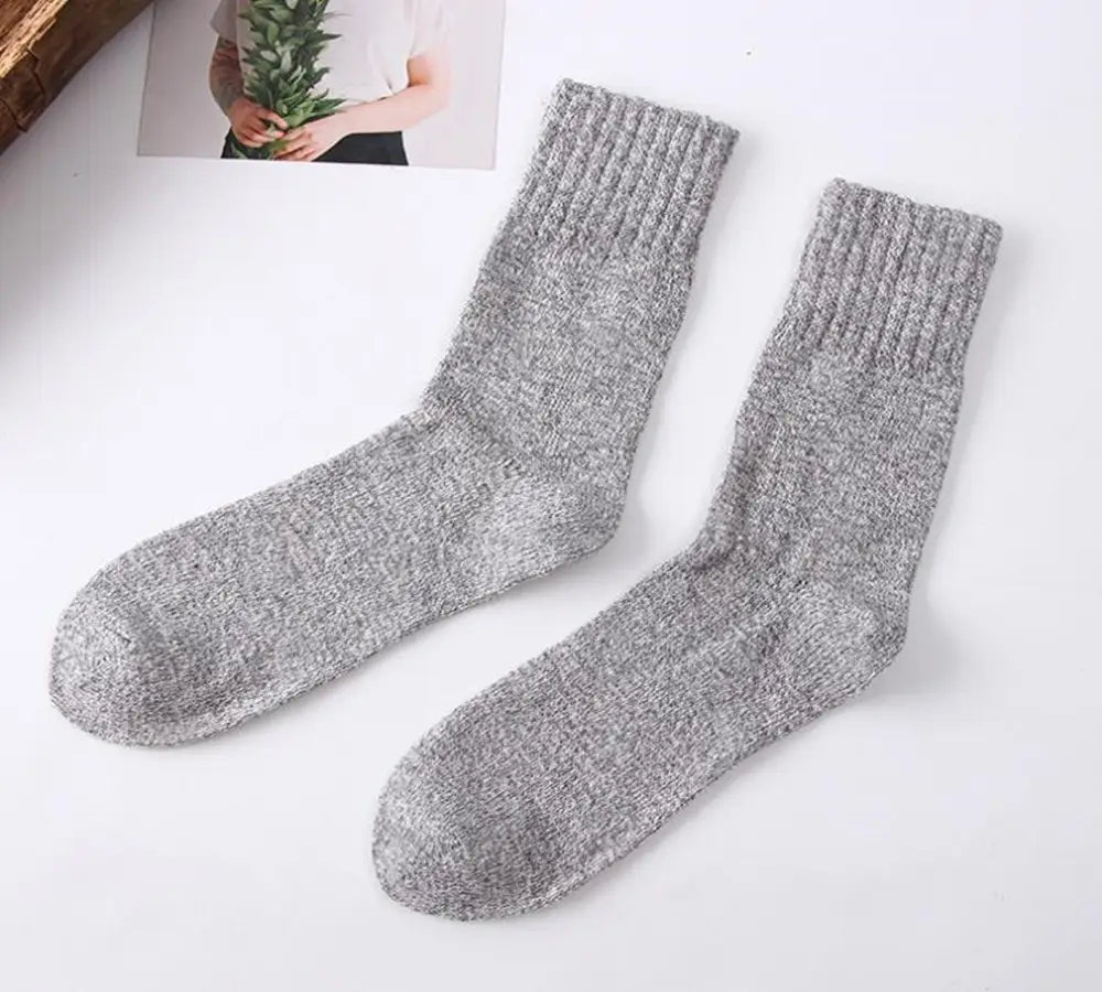 A pair of men’s rabbit fur winter socks in heather gray ribbed knit with a soft textured surface.