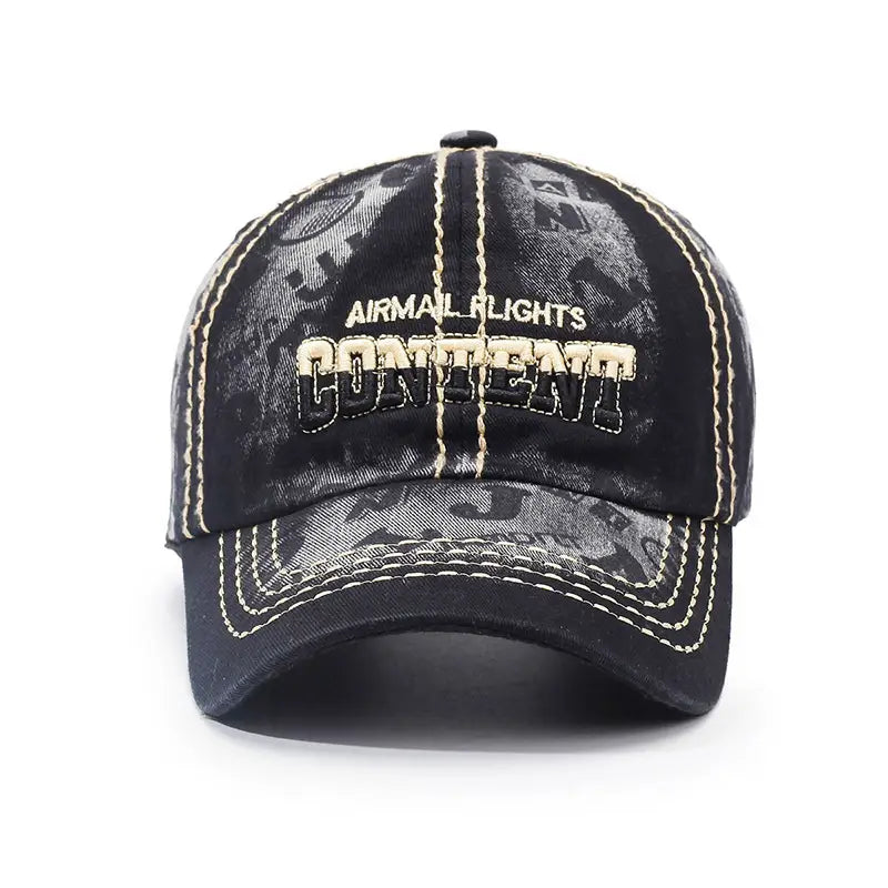 Black denim distressed washed cotton baseball cap with faded gray graphic and cream-colored stitching featuring embroidered airmail flights above bold content in vintage style font.