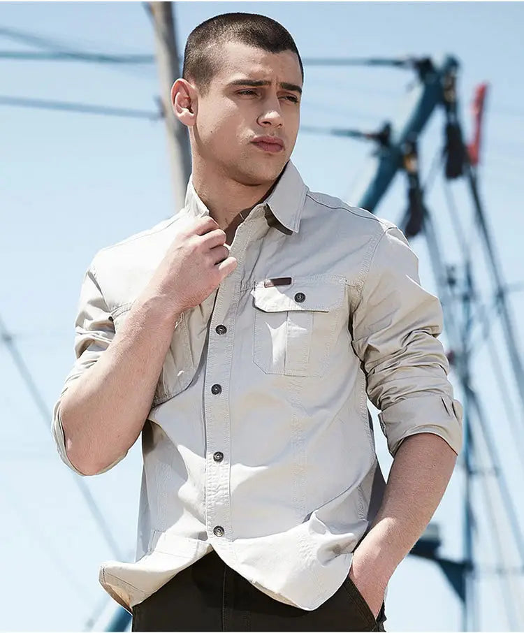 Chemise d’homme d’extérieur à manches longues boutonnée unie beige, avec poche de poitrine et manches retroussées.