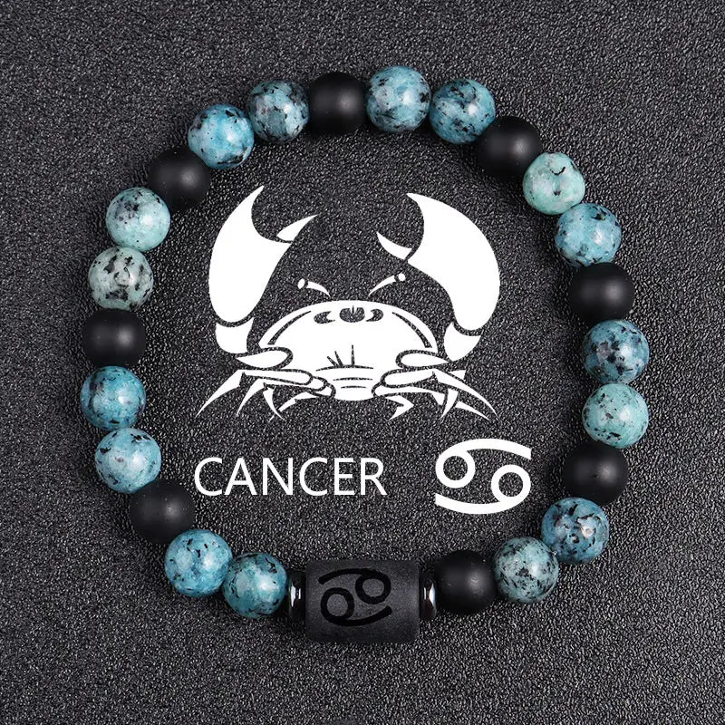 A natural stone 12 constellation zodiac obsidian bracelet featuring a cancer theme with alternating teal and black beads and a central black bead engraved with the cancer symbol.