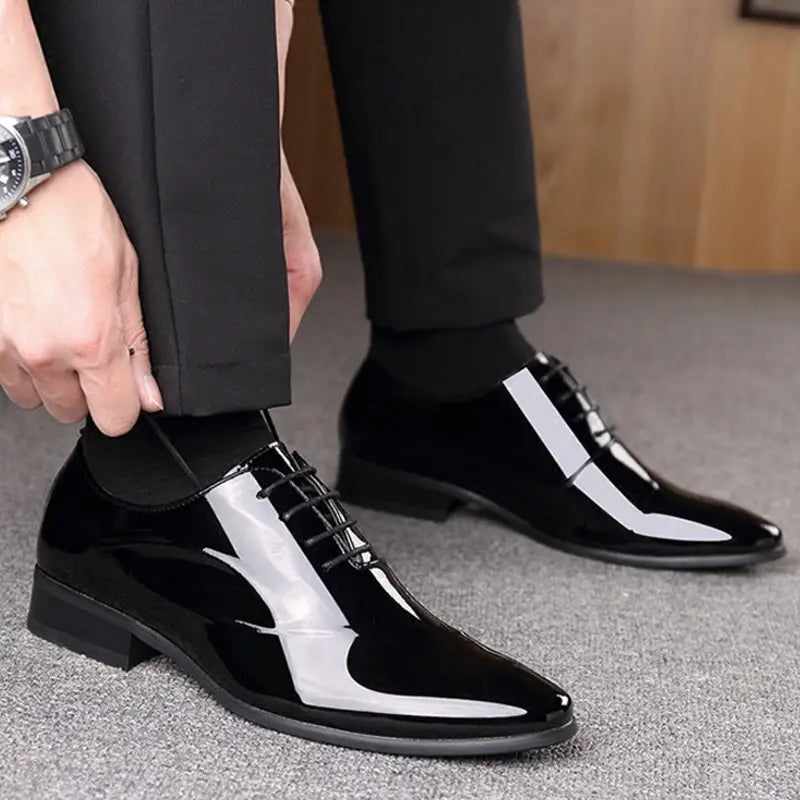 Men’s classic pointed toe leather business shoe in black patent leather with a glossy finish and white toe panel.