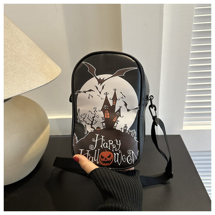 Black embroidered halloween floral and pumpkin crossbody bag featuring a spooky castle, bats, and happy halloween text on the front.