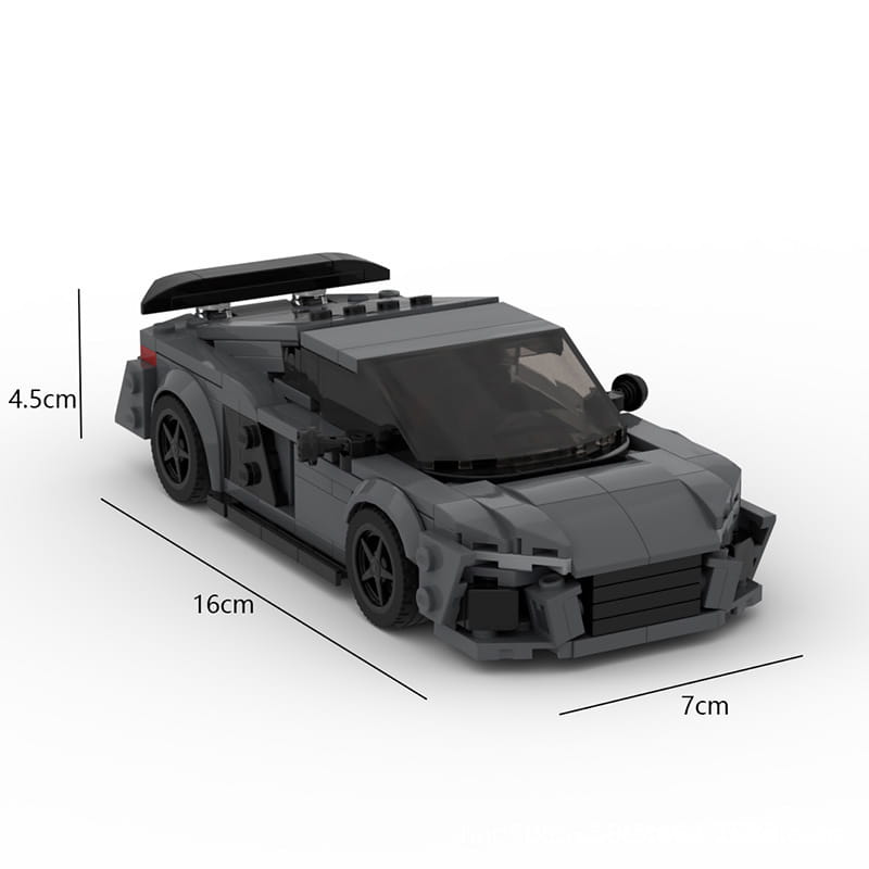 Un elegante automóvil de carreras de color gris oscuro, construido con piezas de lego, modelo educativo deportivo con alerón trasero negro y parrilla delantera detallada.