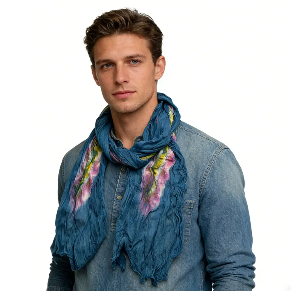 Ein Türkis-Tie-Dye-Baumwoll-Crinkle-Schal mit einer strukturierten tiefblauen Stoffoberfläche und einem lebhaften floralen Muster aus Pink und Gelb.