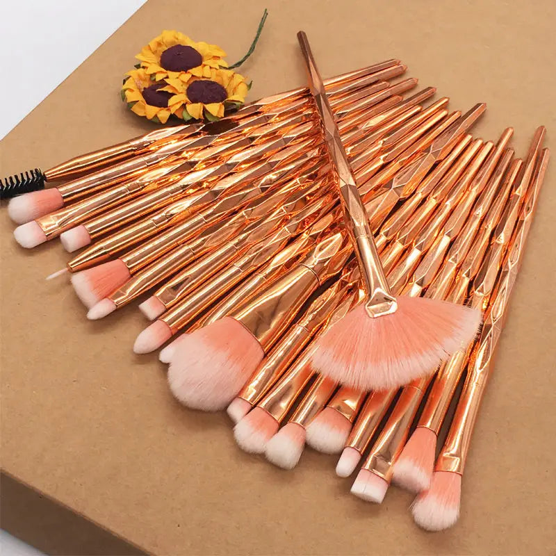 Set of rose gold finished makeup brushes with soft peach and white bristles from a 20 piece rose gold and glitter makeup brush set.